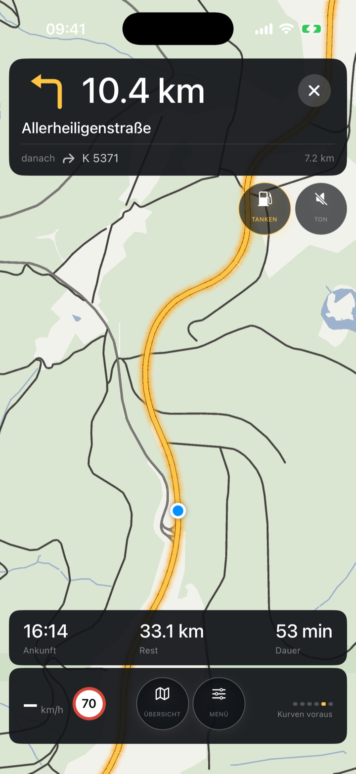 AuraCurve-Navigation: goldene Kurven-Route durch Serpentinen mit Manöver-Banner, Tank-Chip und Kurvenband